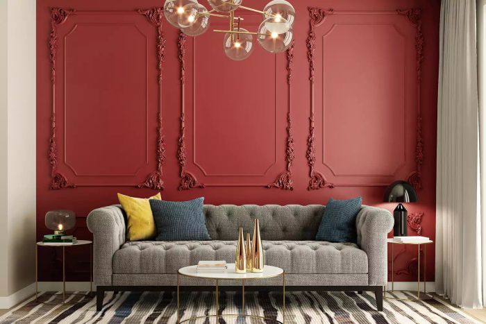 A classic interior design concept featuring burgundy walls, elegant wall panelling, a cozy sofa, and a stylish hanging light fixture.