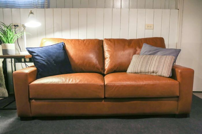 The Pottery Barn Turner Square Arm Leather Sofa, accessorized with pillows.