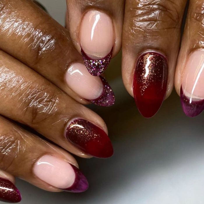Dark red nails, alternating between French styles and single-color manicure every other finger with sparkles.