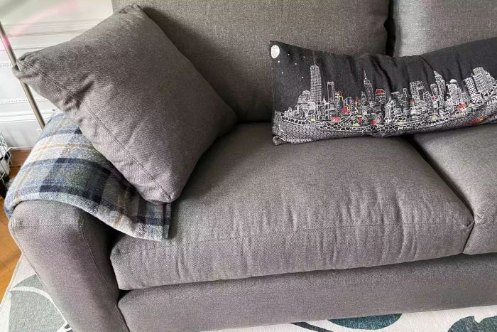 Close-up shot of the Room & Board Metro Sofa with a cozy blanket and pillows