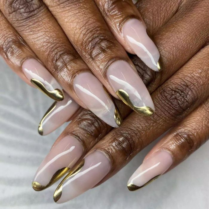 Nude manicure with metallic gold drips.