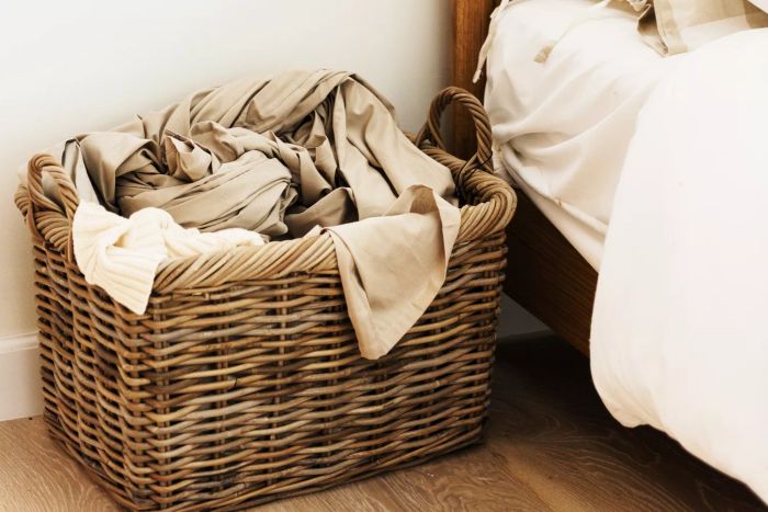 laundry basket placed beside the bed