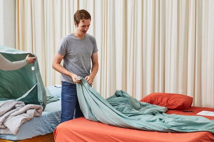 An individual holding a corner of the Buffy Breeze Comforter