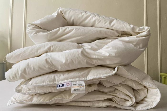 The Fluff Co Down Blended Comforter neatly folded on a bed