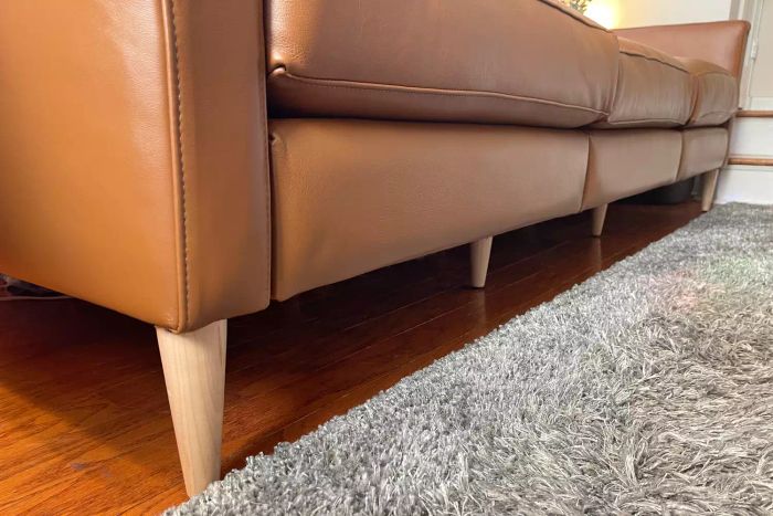 A close-up view of the wooden legs of the Allform 3-Seat Sofa