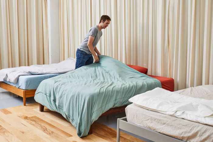 A person neatly arranging the Buffy Breeze Comforter on a bed