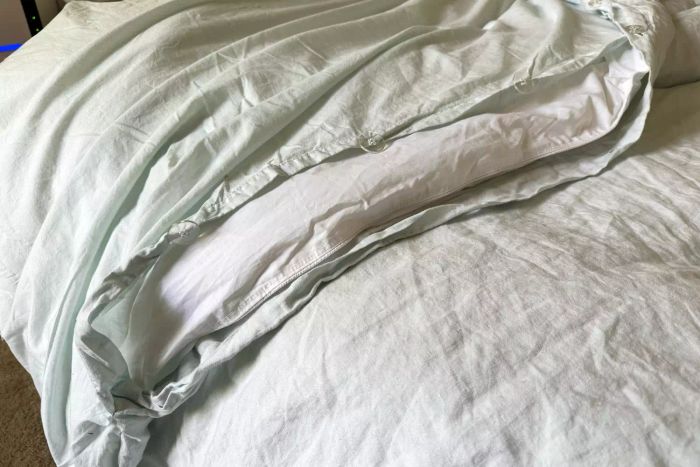 The Saatva Lightweight Down Alternative Comforter displayed elegantly on a bed
