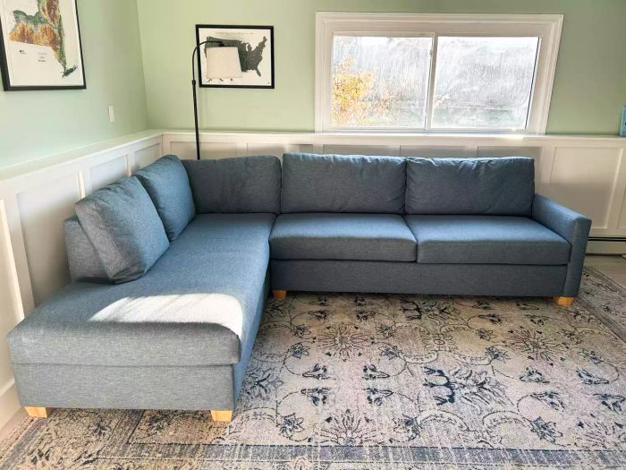 Apt2B Tuxedo 2-Piece Sleeper Sectional placed on a patterned rug in the corner of a cozy living room.