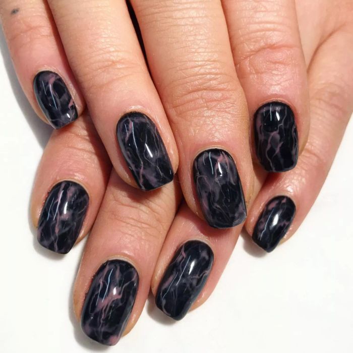 Black nails with a smokey design.