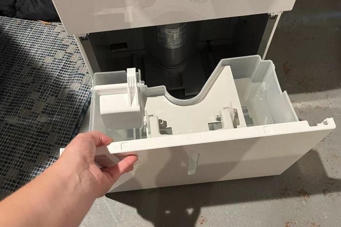 A hand detaching a compartment from the Homelabs 50-Pint Wi-Fi Dehumidifier HME031003N