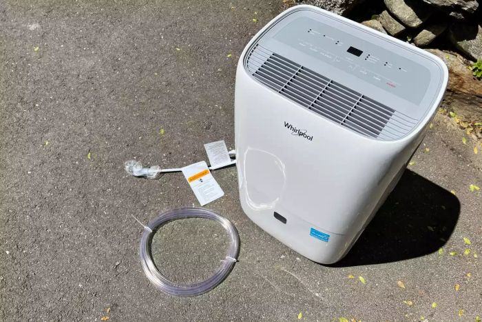 A top view of the Whirlpool Portable Dehumidifier with the drain tube placed beside it.