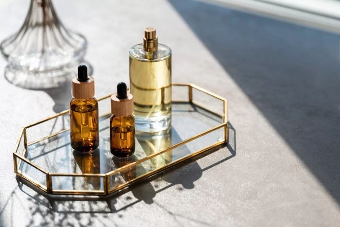 A variety of cosmetic items and mirrors on a table, with unmarked perfume bottles and samples. Beauty concept.