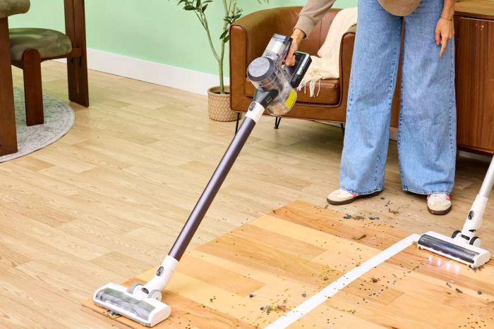 A person cleaning a wooden surface with the Tineco Pure One S11 Vacuum