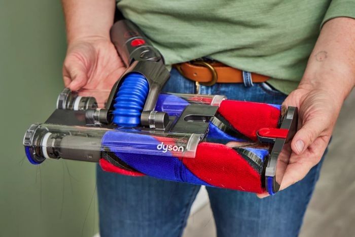 Two hands grasping a section of the Dyson Omni-Glide Cordless Vacuum