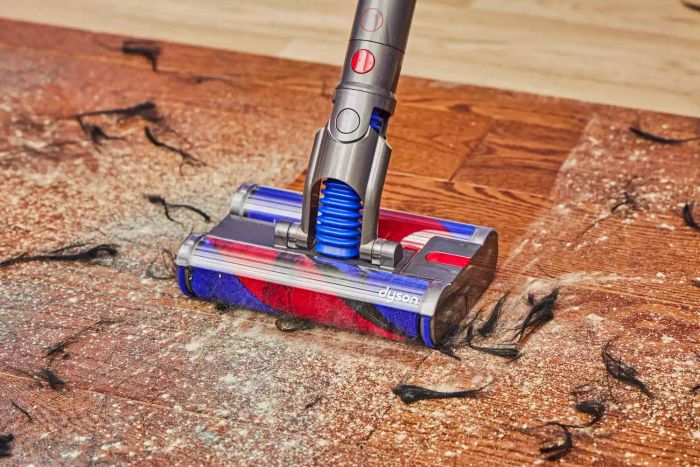 The Dyson Omni-Glide Cordless Vacuum cleaning up a mess from hardwood