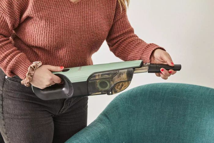 A woman adjusting the nozzle of the Shark UltraCyclone Pro Cordless Handheld Vacuum.