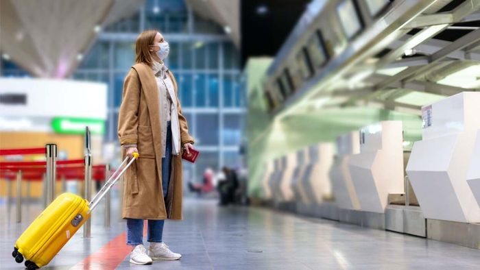 A traveler hesitates with a suitcase in hand, unsure of the next step.