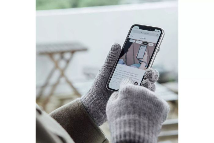 A person using their phone while wearing Moshi Digits Touchscreen Gloves