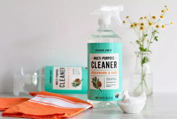 A photo of Trader Joe's Multi-Purpose Cleaner placed beside a towel and vase