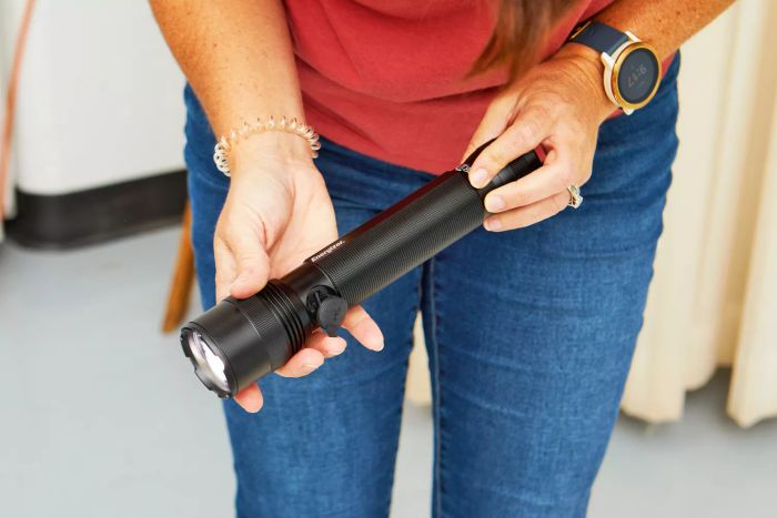 A person activating an Energizer TacR-1000 LED Tactical Flashlight.