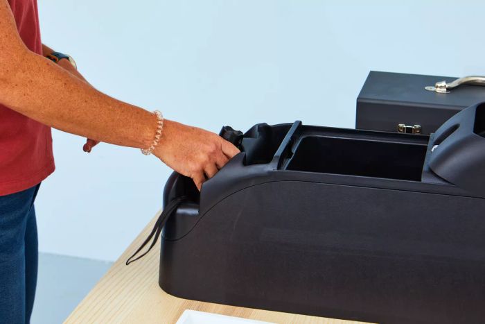 A person placing a GearLight S100 LED Tactical Flashlight back into storage.