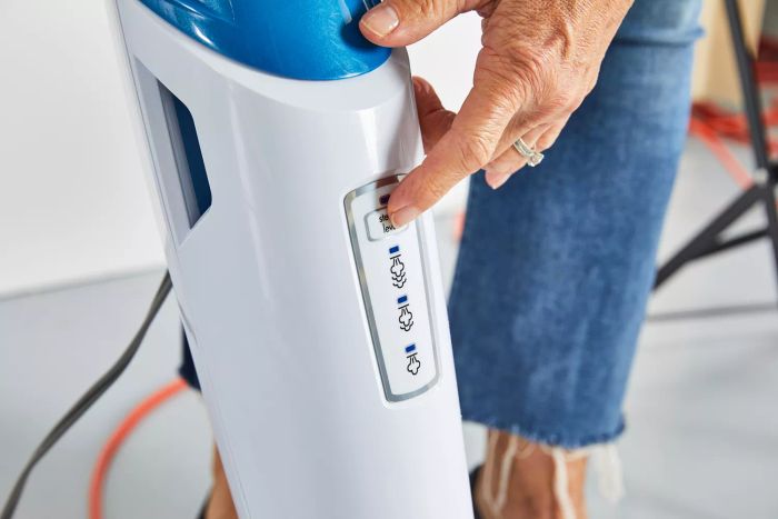 Close-up of a user adjusting the steam settings on the Bissell 1940 PowerFresh Scrubbing & Sanitizing Steam Mop