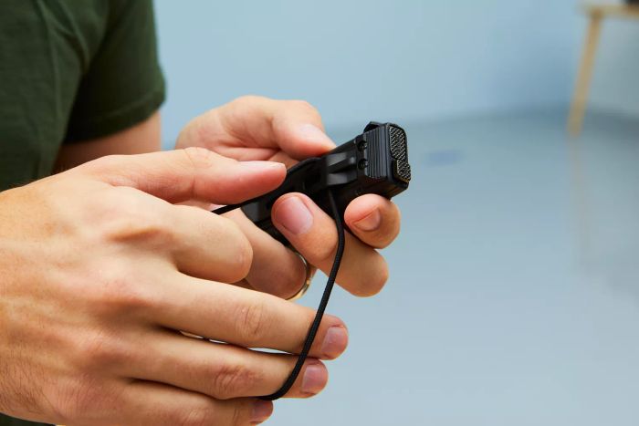 A person holding the Nitecore EDC27 Ultra Slim Flashlight in their hand.