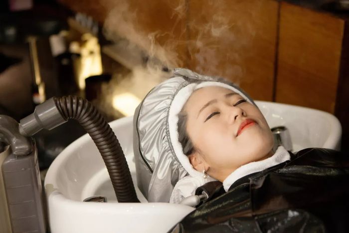 Woman receiving a scalp steam treatment
