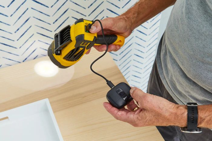 person connecting the Stanley Fatmax Rechargeable Lithium Ion LED Spotlight Flashlight to a power source