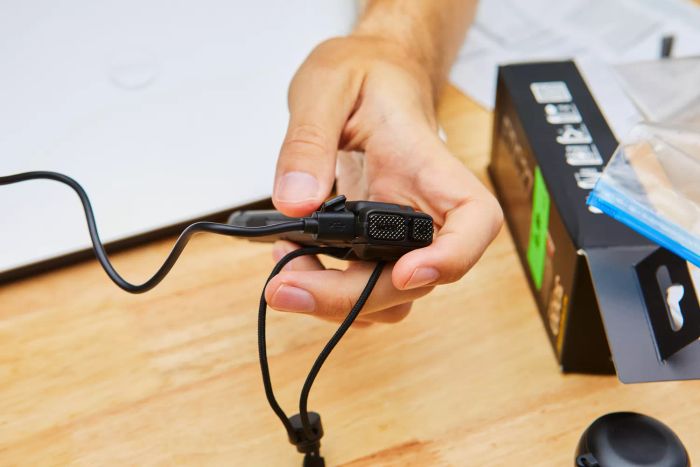 A person holding the Nitecore EDC27 Ultra Slim Flashlight while it’s in the process of charging.