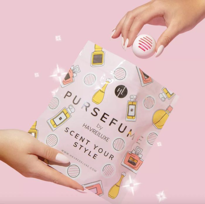 a hand holding a pink pursefume pod