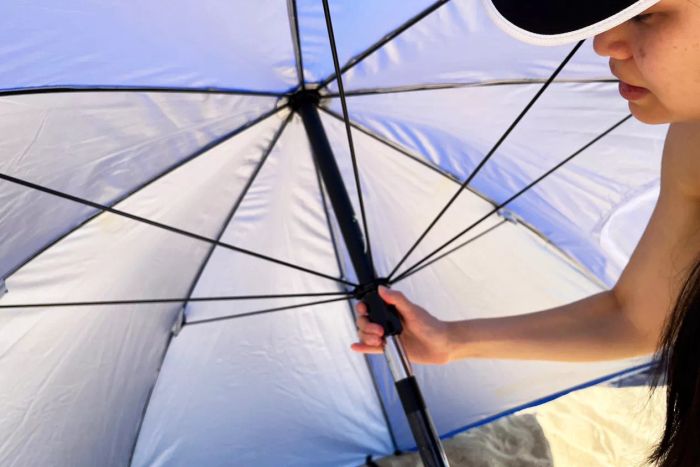 Close-up of an individual assembling the Sport-Brella Versa-Brella SPF 50+ Adjustable Umbrella.
