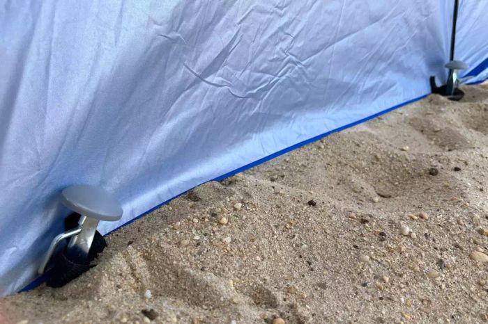 Close-up view of the ground spikes from the Sport-Brella Premiere 8-foot Outdoor Umbrella anchored in the sand.