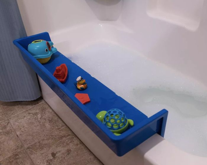 a blue container filled with toys on the edge of a bathtub