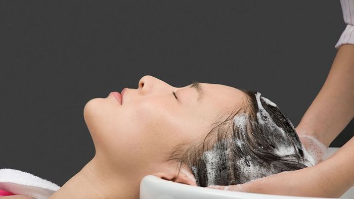 woman applying shampoo to her hair