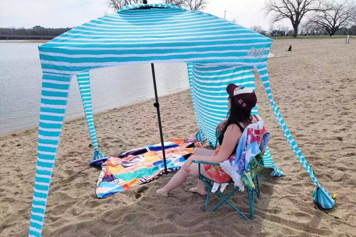 A person relaxing under the Qipi Beach Cabana