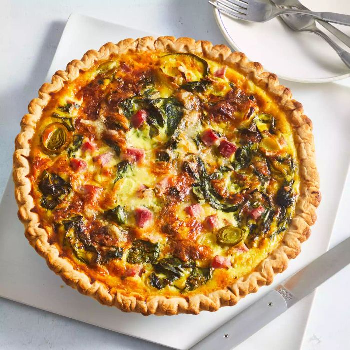 A delicious ham and leek quiche presented against a pristine white backdrop.
