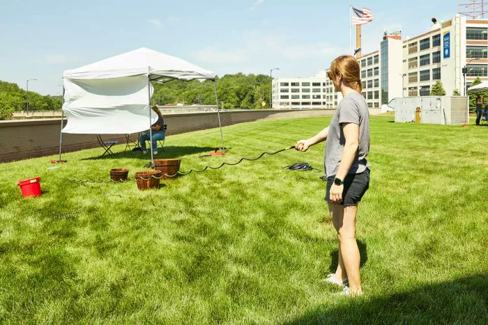 A person watering the grass using the Water Right Coil Garden Hose