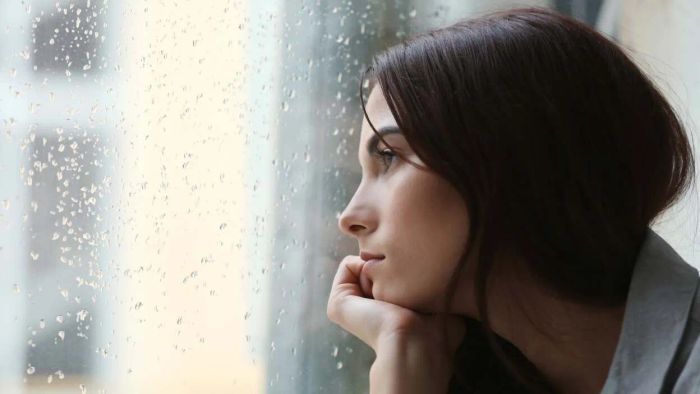A woman gazes out the window, deep in thought.
