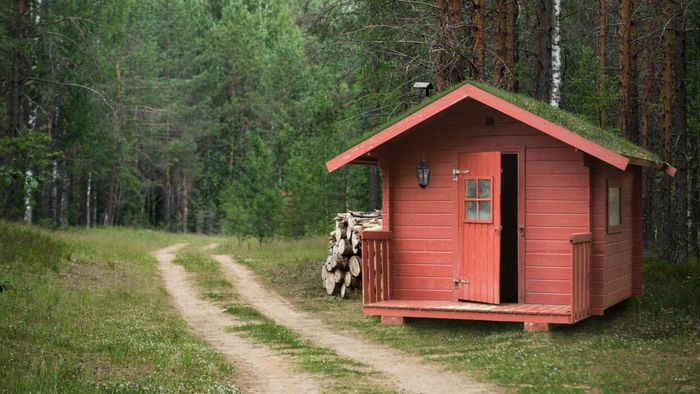 A cozy red cabin with a welcoming front door, nestled beside a winding dirt path leading into the forest.