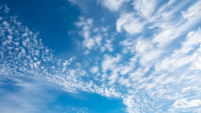 A sky painted with faint, wispy clouds.