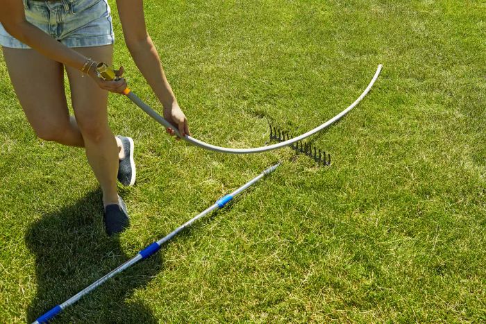 A person dragging the Eley 5/8-Inch Polyurethane Garden Hose across the grass.