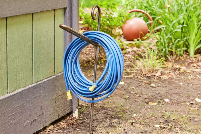 H2O Works Garden Flat Soaker Hose coiled on a stand in a garden.