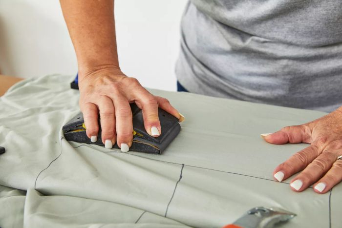A person using a sanding tool on the Bamboo Bay 4-Piece Bamboo Sheet Set.