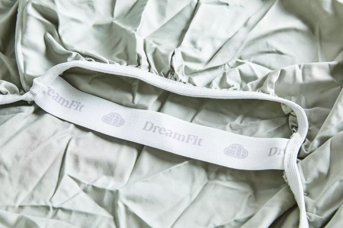 A close-up view of the DreamFit logo on the DreamChill Collection Enhanced Bamboo Sheet Set.