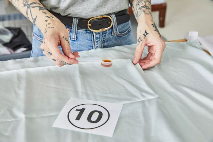 A person holding a spoon with liquid next to the Bamboo Bliss Resort Collection by RHH Sheet Set.