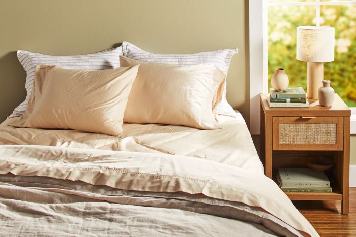 The Brooklyn Bedding Deep Pocket Bamboo Cotton Sheets arranged on a bed, accompanied by pillows and a nightstand beside them.