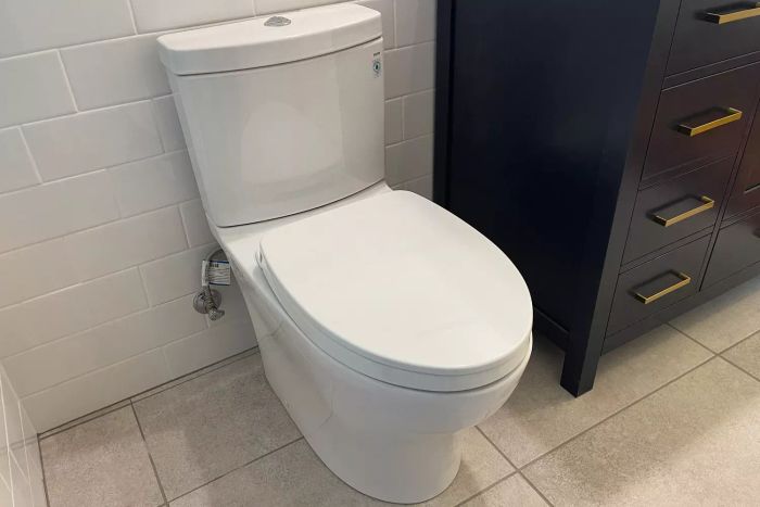The Toto Aquia IV One-Piece Comfort Height Toilet, positioned in the bathroom with its lid shut
