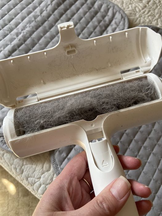A reviewer displays the interior of a used roller filled with collected hair