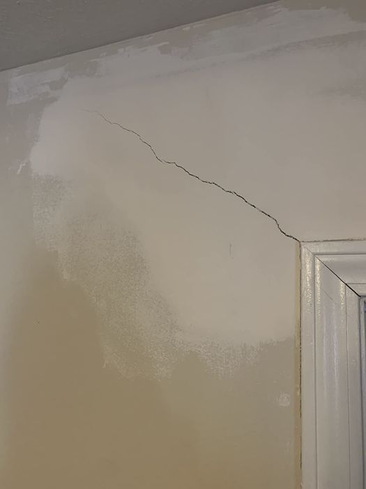 A reviewer's photo of a wall featuring a noticeable long crack